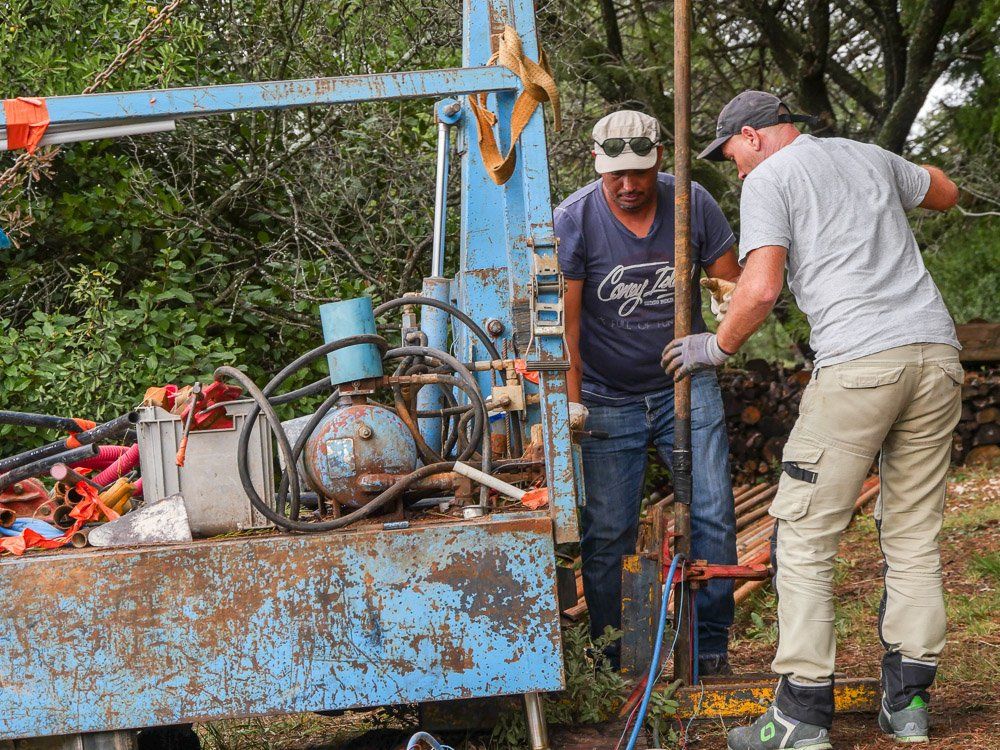 Deux techniciens qui installent des pieux pour consolider la structure