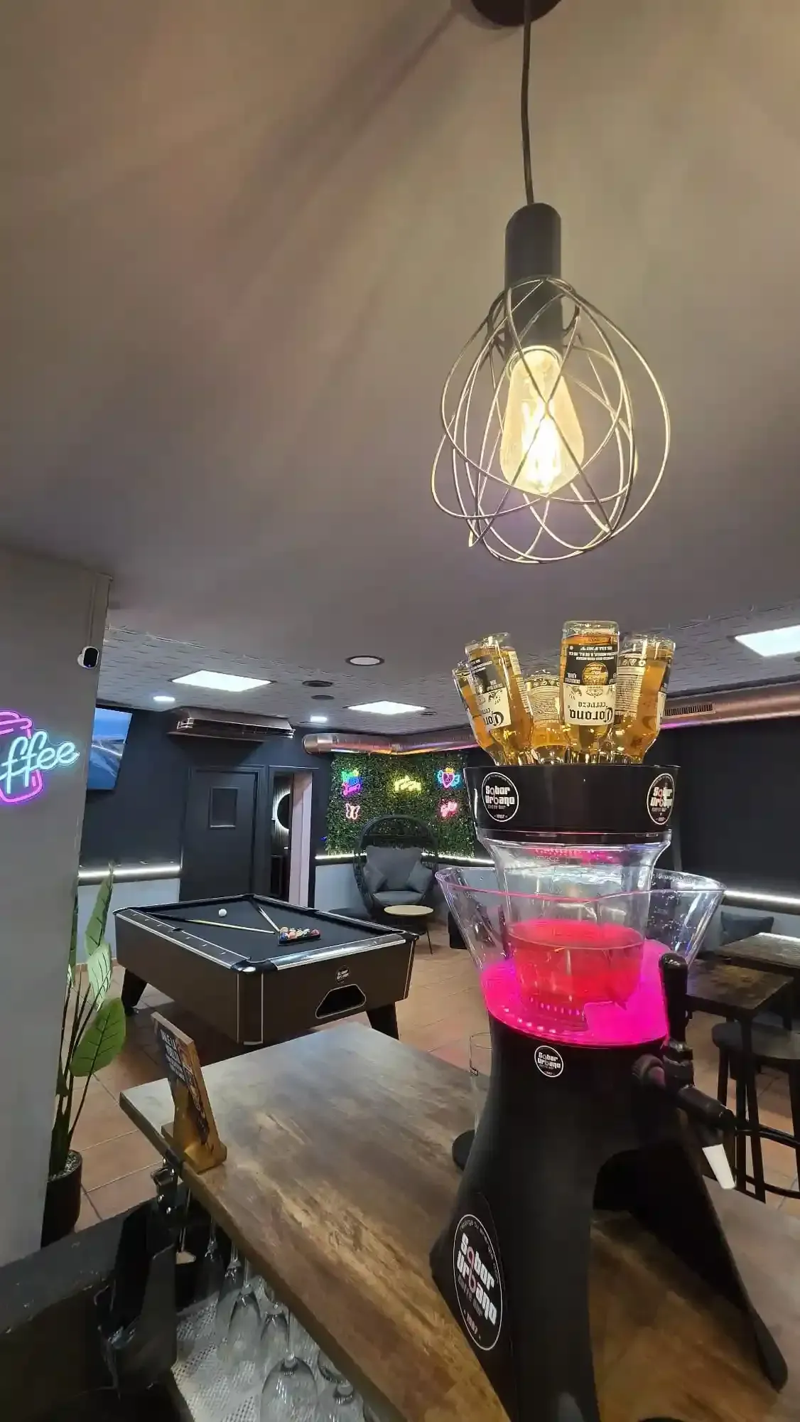 Mujer en una mesa redonda de madera, celebrando un cumpleaños, sosteniendo un globo, con decoraciones de Halloween.