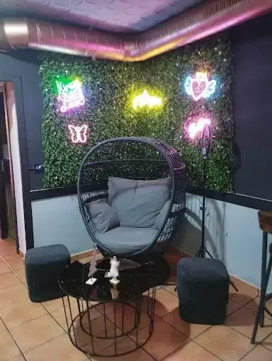 Una acogedora sala de estar con un sillón tipo huevo, dos otomanas y una mesa de café redonda.