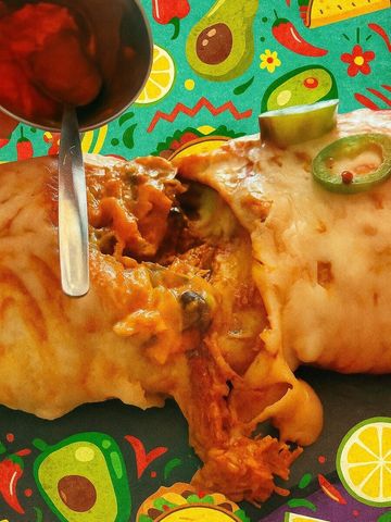 Burrito cubierto de salsa, parcialmente abierto, con jalapeños y aguacate, sobre un colorido fondo de temática mexicana.