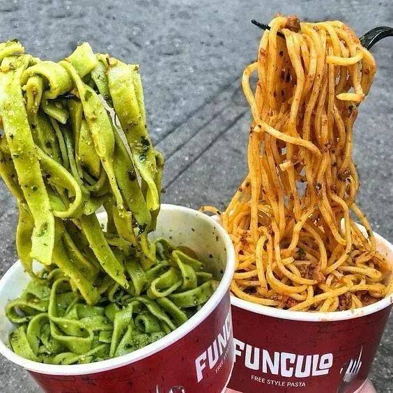 Dos tazones de fideos, uno verde y otro naranja.