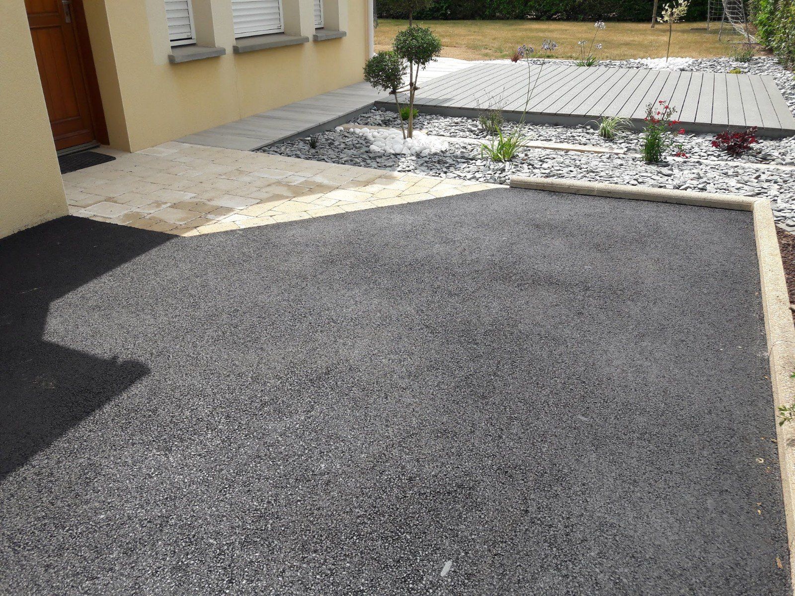 Pose d'enrobé noir devant une porte