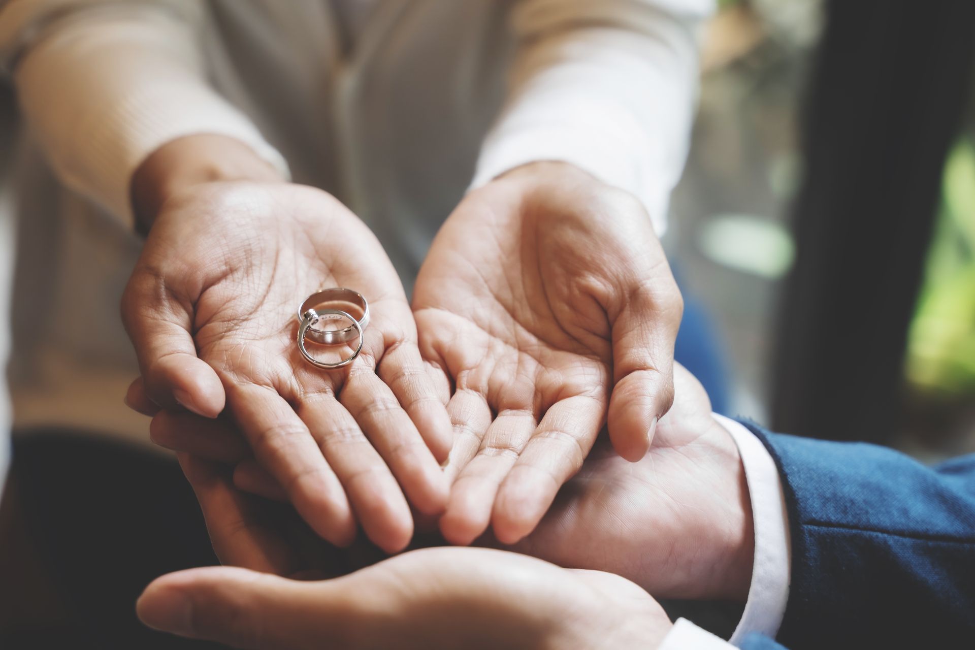 Alliances posées dans les mains d'une femme, tendues au dessus des mains d'un homme