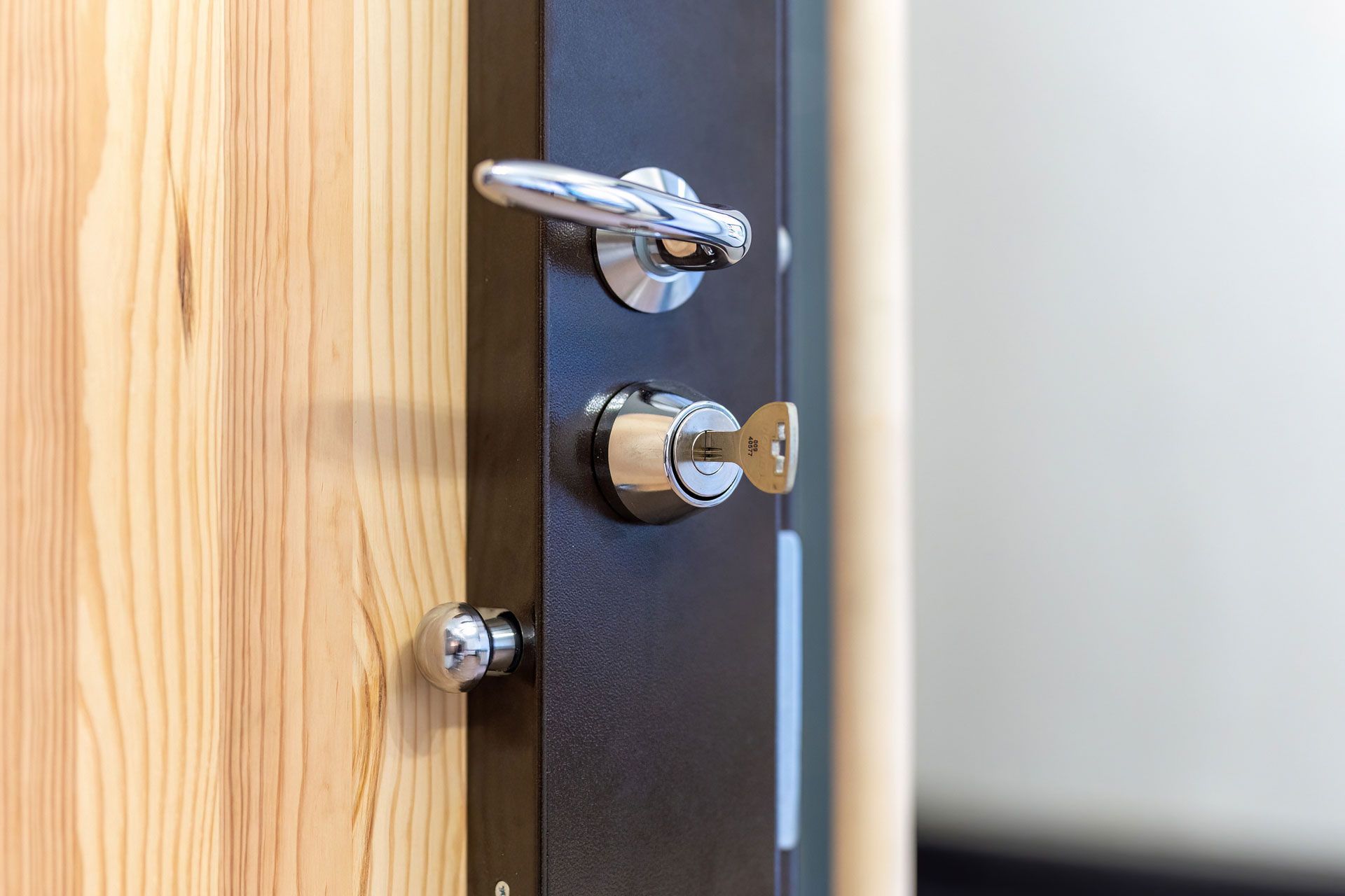 Une serrure en applique et sa clef installée sur une porte