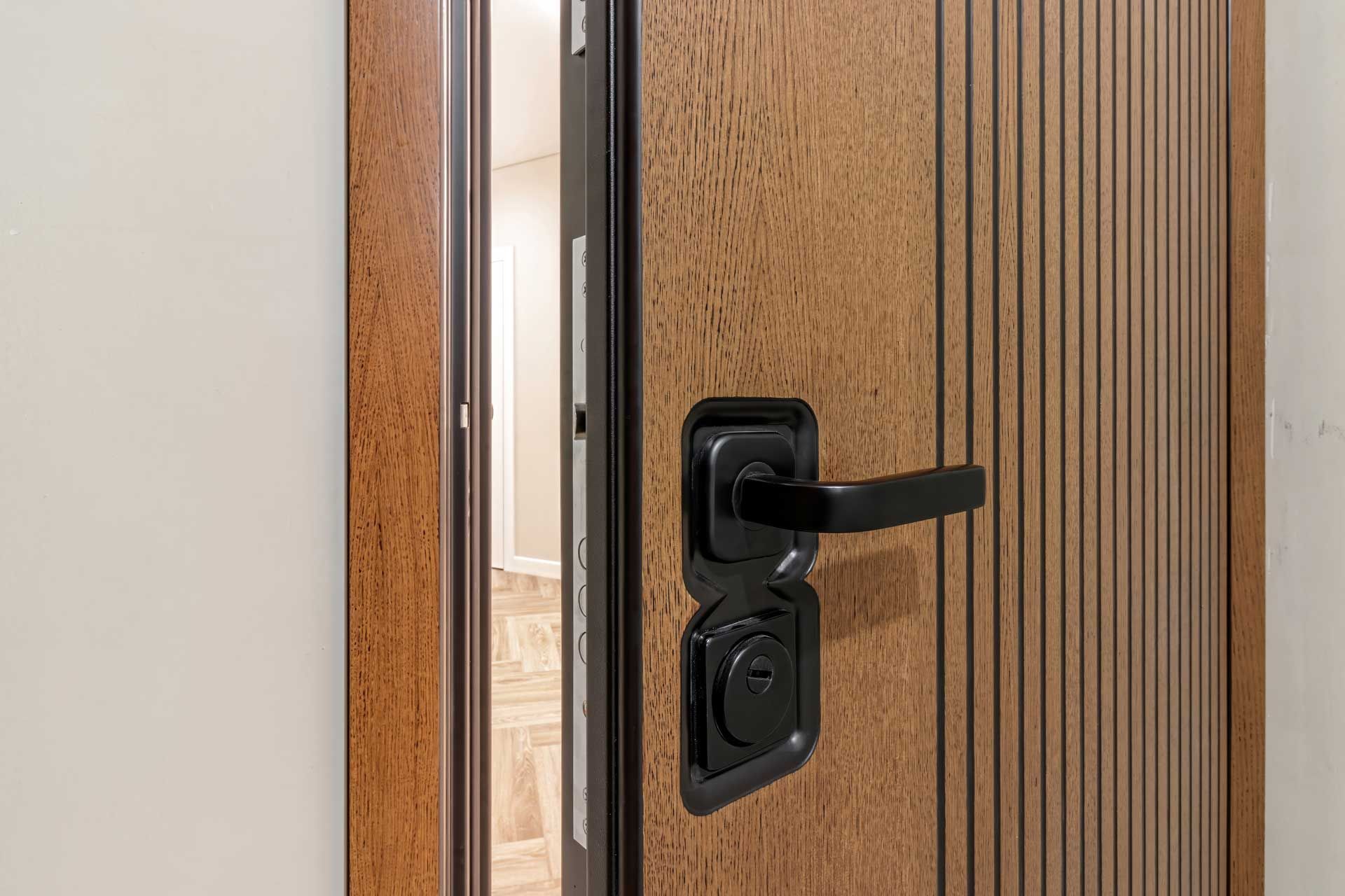 Une porte blindée imitation bois entrouverte