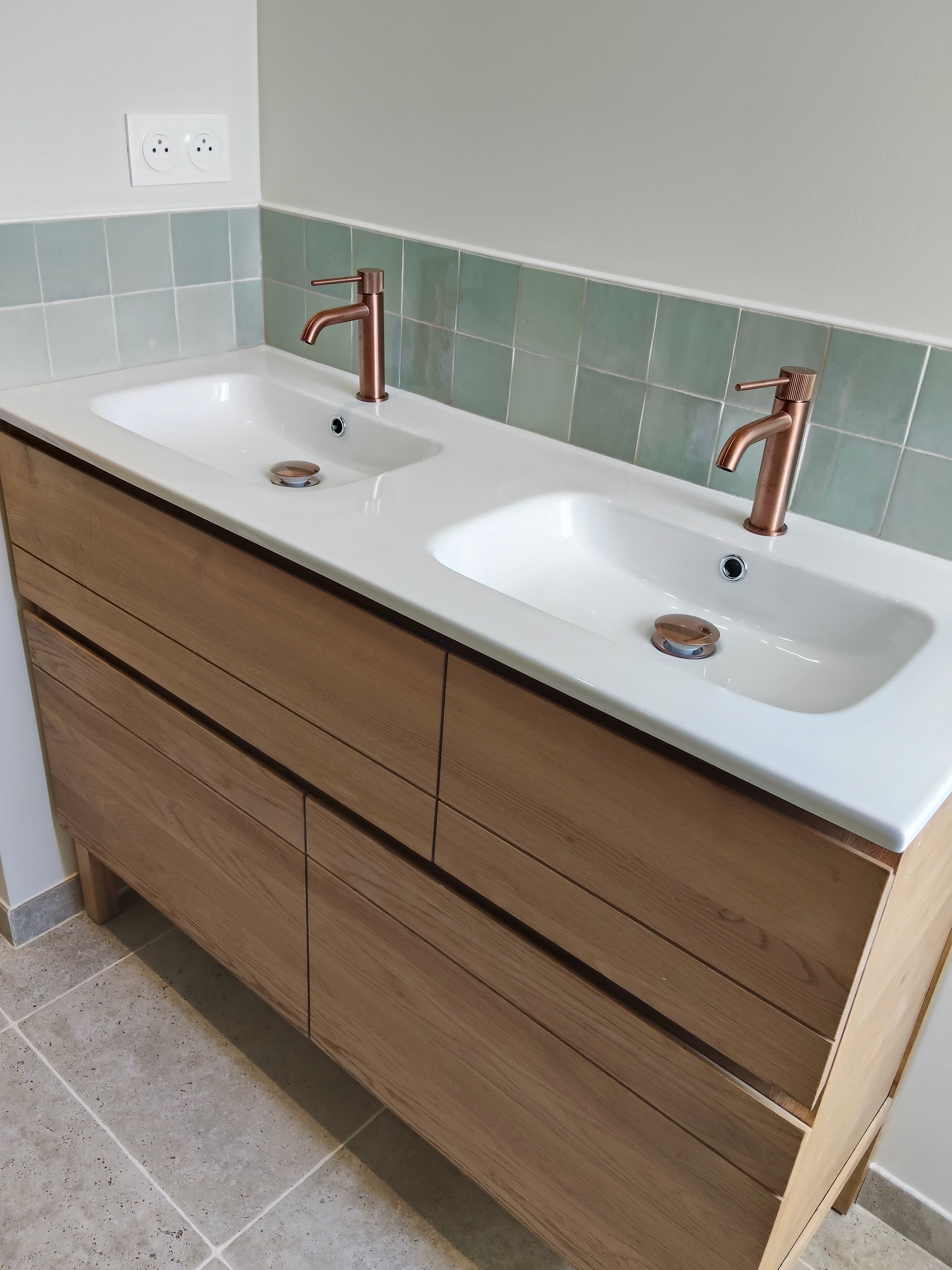 Meuble-lavabo double avec comptoir, robinetterie et armoires.