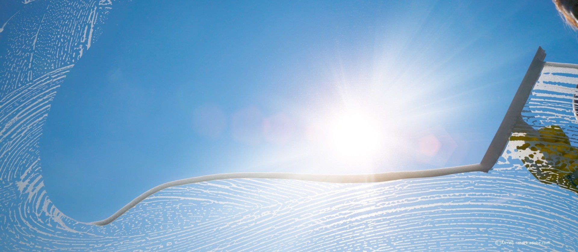 Gebäudereinigung Weigand – Person reinigt eine Fensterscheibe