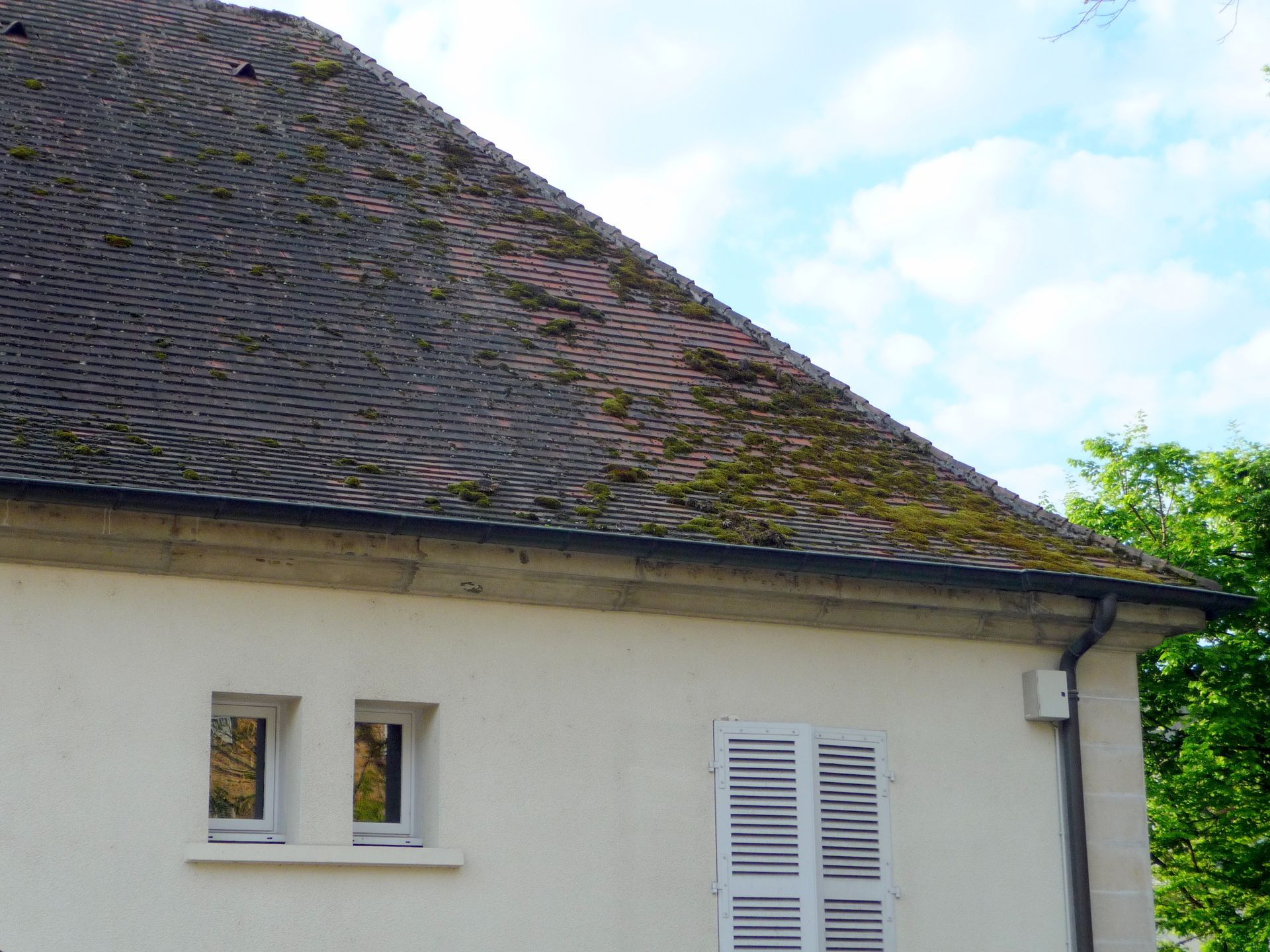 Homme sur une toiture avec un accessoire haute pression
