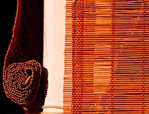 Un primer plano de un rollo de persianas de bambú en una ventana.