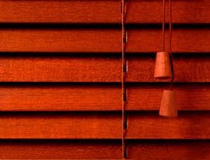 Un primer plano de una persiana de madera con dos cordones colgando de ella.