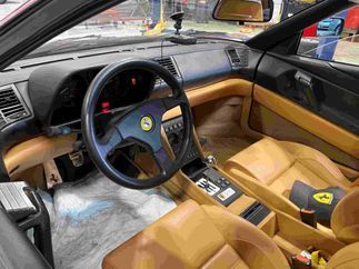 El interior de un ferrari rojo con volante y asientos.