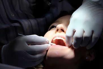 Una mujer está siendo examinada por un dentista.