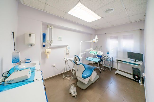 Un consultorio dental con un sillón dental y una computadora.