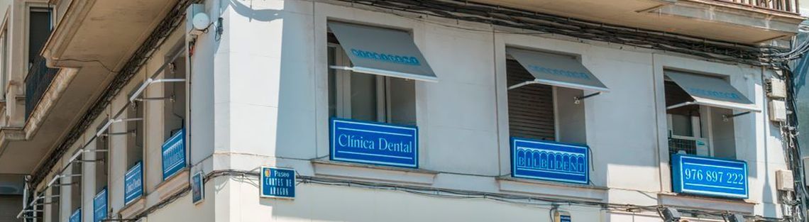 Un edificio blanco con toldos azules en las ventanas.