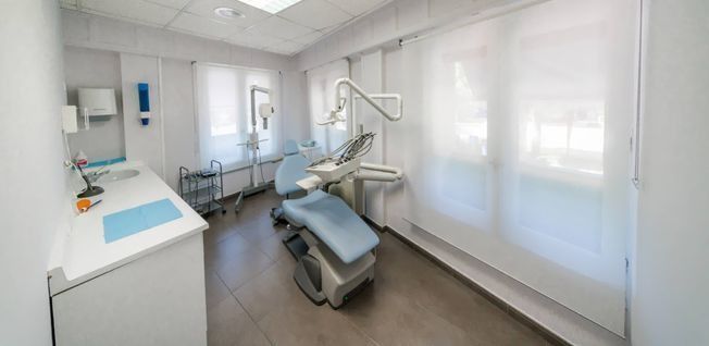 Un consultorio dental con un sillón dental y un mostrador.