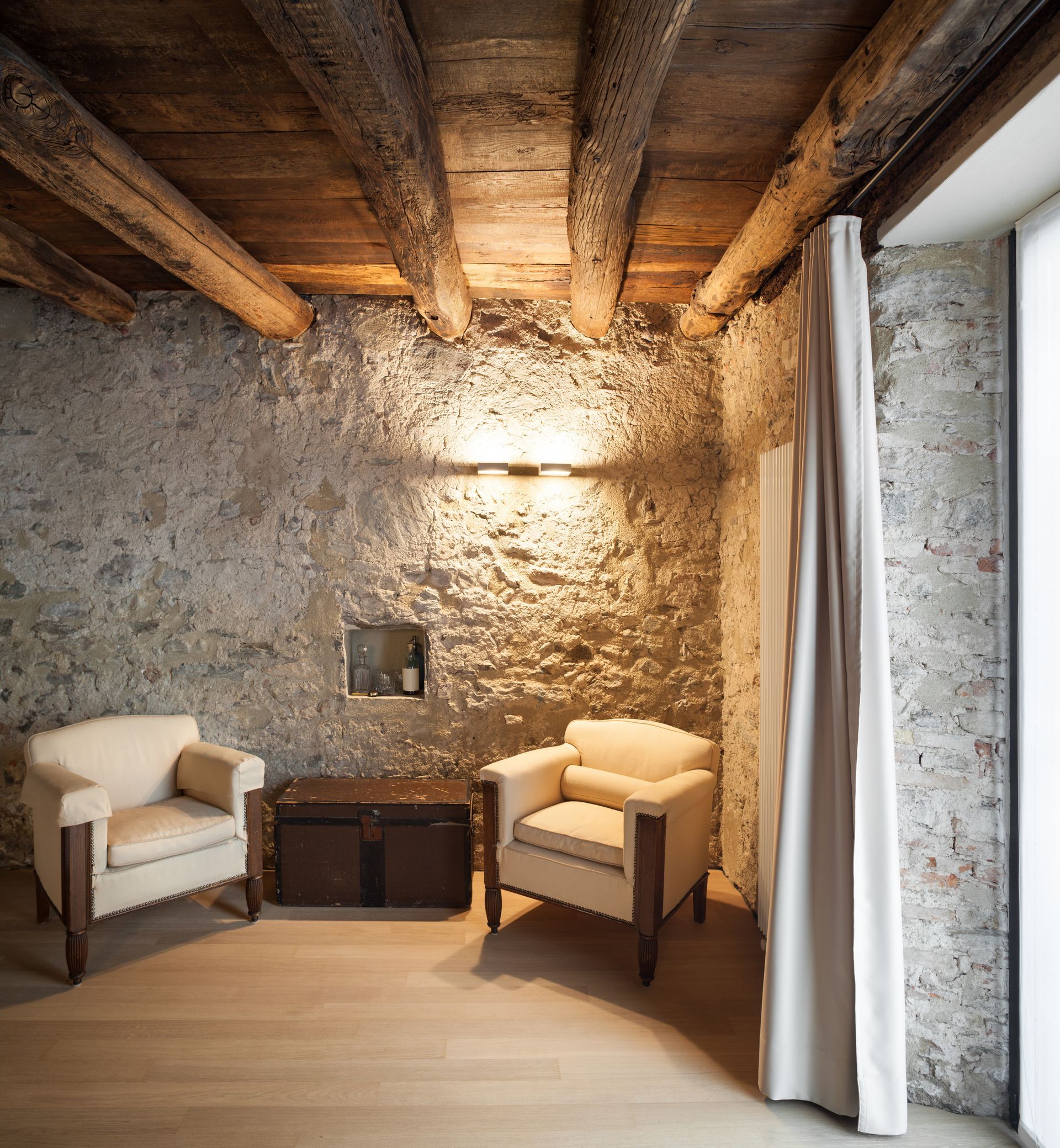 Deux fauteuils et un coffre dans une maison ancienne en pierre