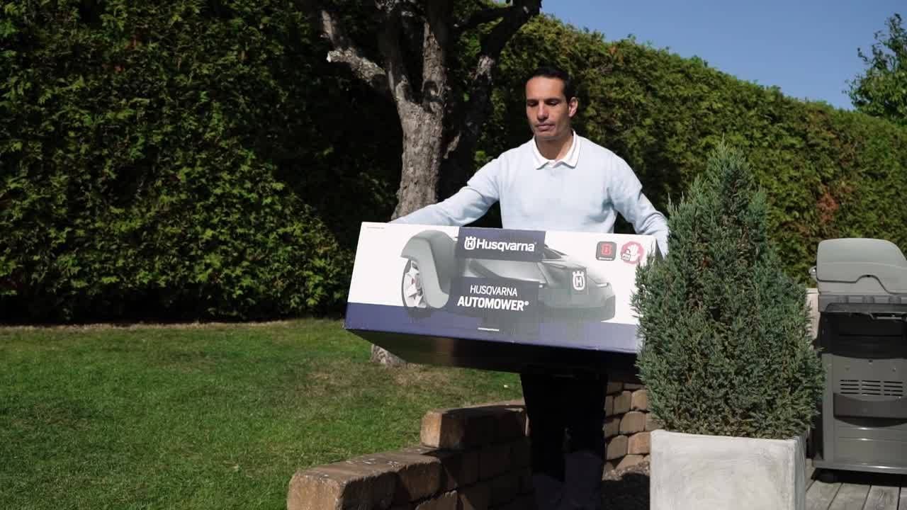 Mann mit einem Husqvarna Paket in den Armen