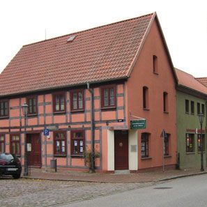Ein Gebäude mit einem roten Ziegeldach steht neben einem anderen Gebäude