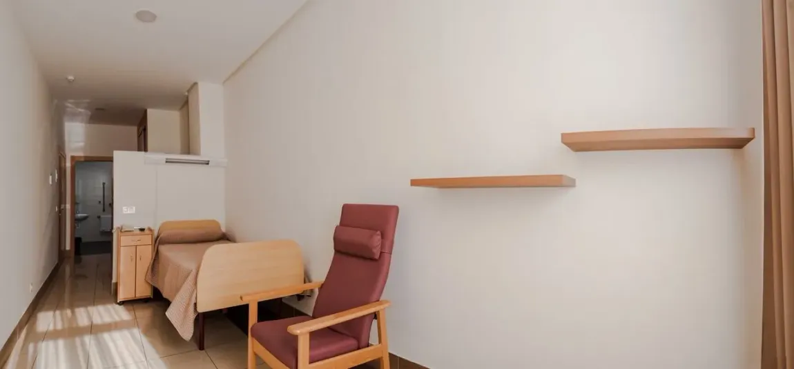 Hay una cama y una silla en la habitación.