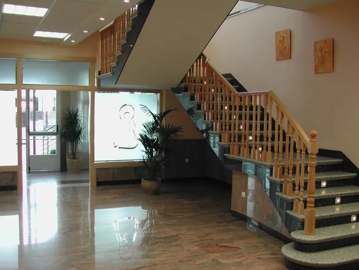 Una escalera con barandilla de madera en un edificio.