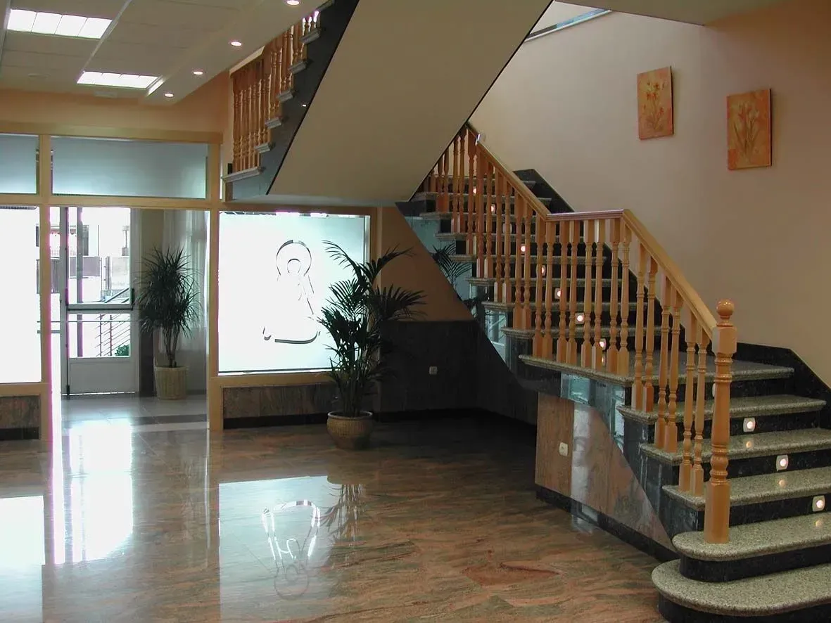 Una escalera con barandilla de madera en un edificio.