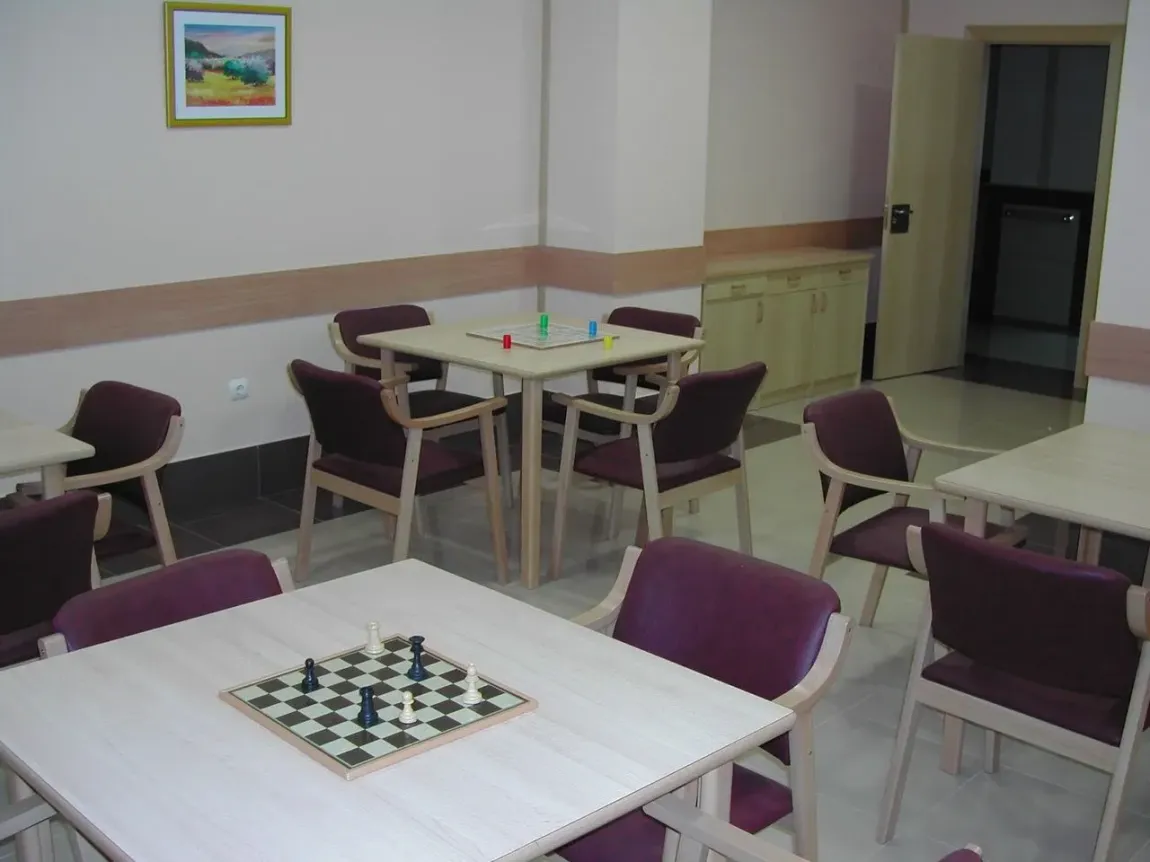Una habitación con mesas y sillas y un tablero de ajedrez.