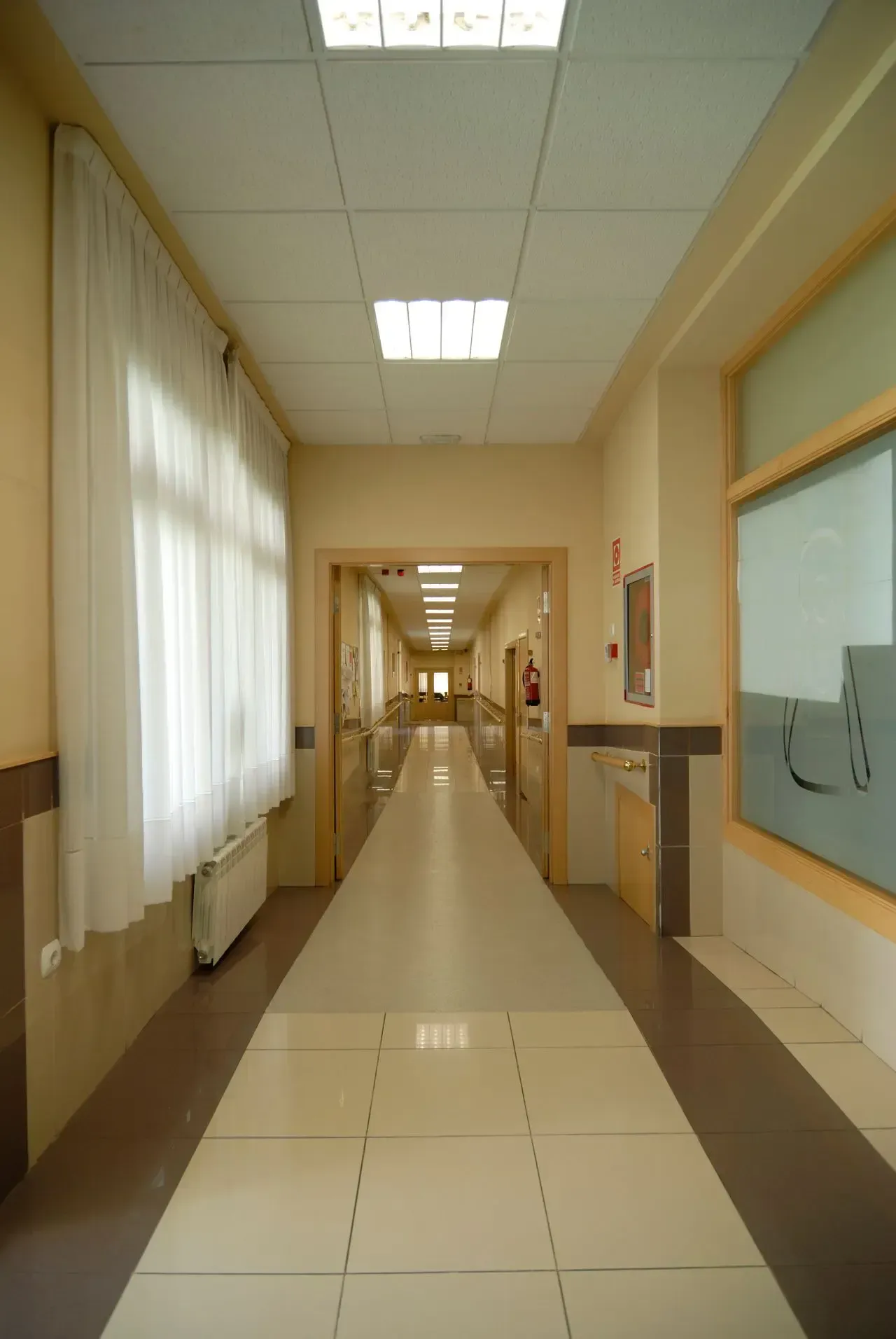 Un largo pasillo con muchas ventanas y cortinas.