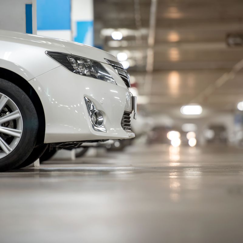 Un coche blanco está aparcado en un aparcamiento.