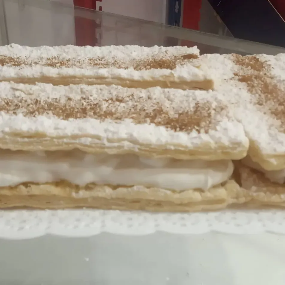 Bandeja de barritas de hojaldre en capas espolvoreadas con coco y azúcar glas.