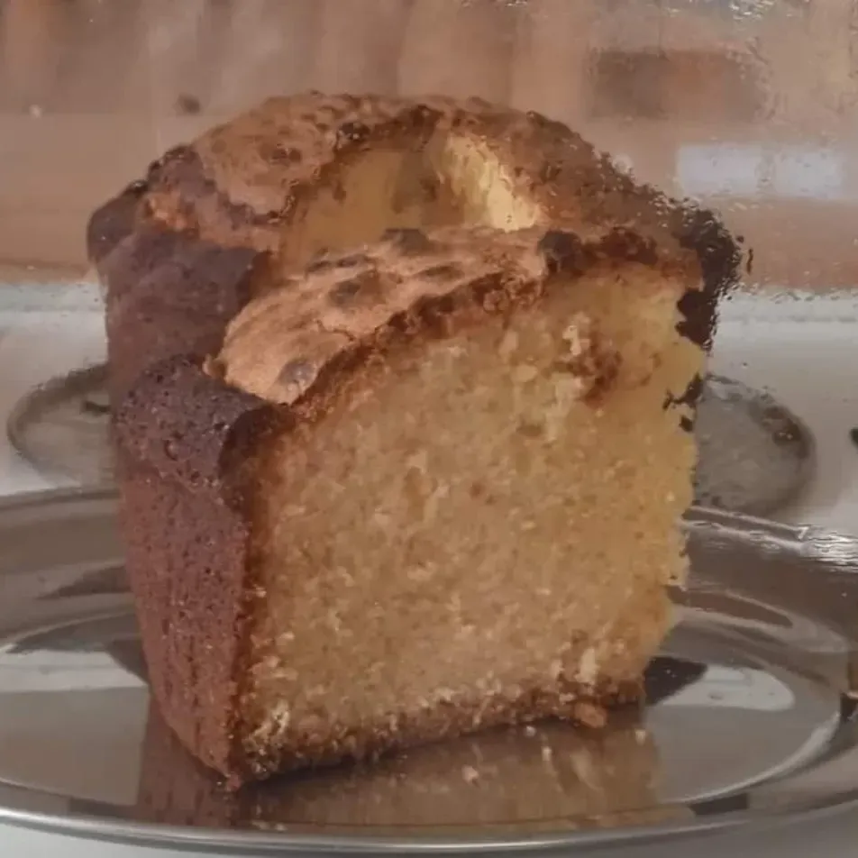 Una rebanada de bizcocho marmolado sobre un plato de cristal transparente.