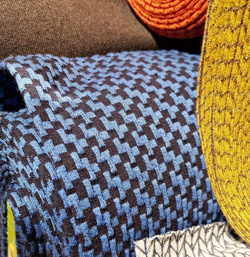 Tissu à motifs bleus et noirs ; autres tissus bruns, oranges et jaunes.