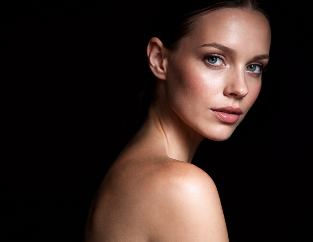 Una persona applica un cerotto sulla guancia di una donna durante un trattamento spa.