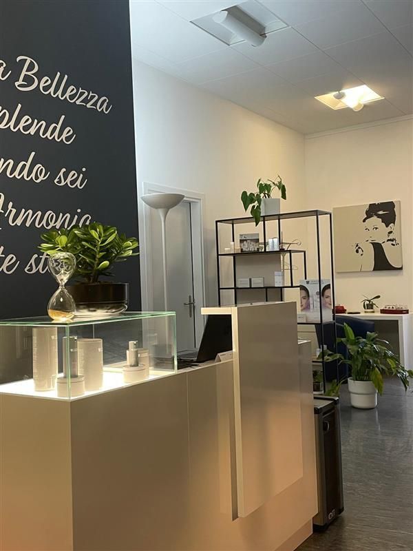 Persona che riceve un trattamento viso con spazzole, sdraiata su un asciugamano bianco, in un ambiente da spa.