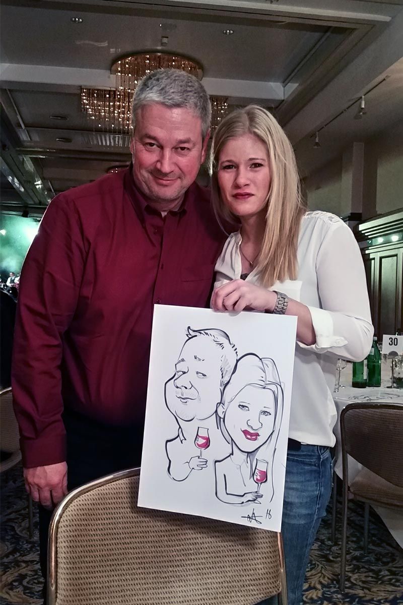 ein Mann und eine Frau stehen nebeneinander und halten eine Karikatur eines Mannes und einer Frau .