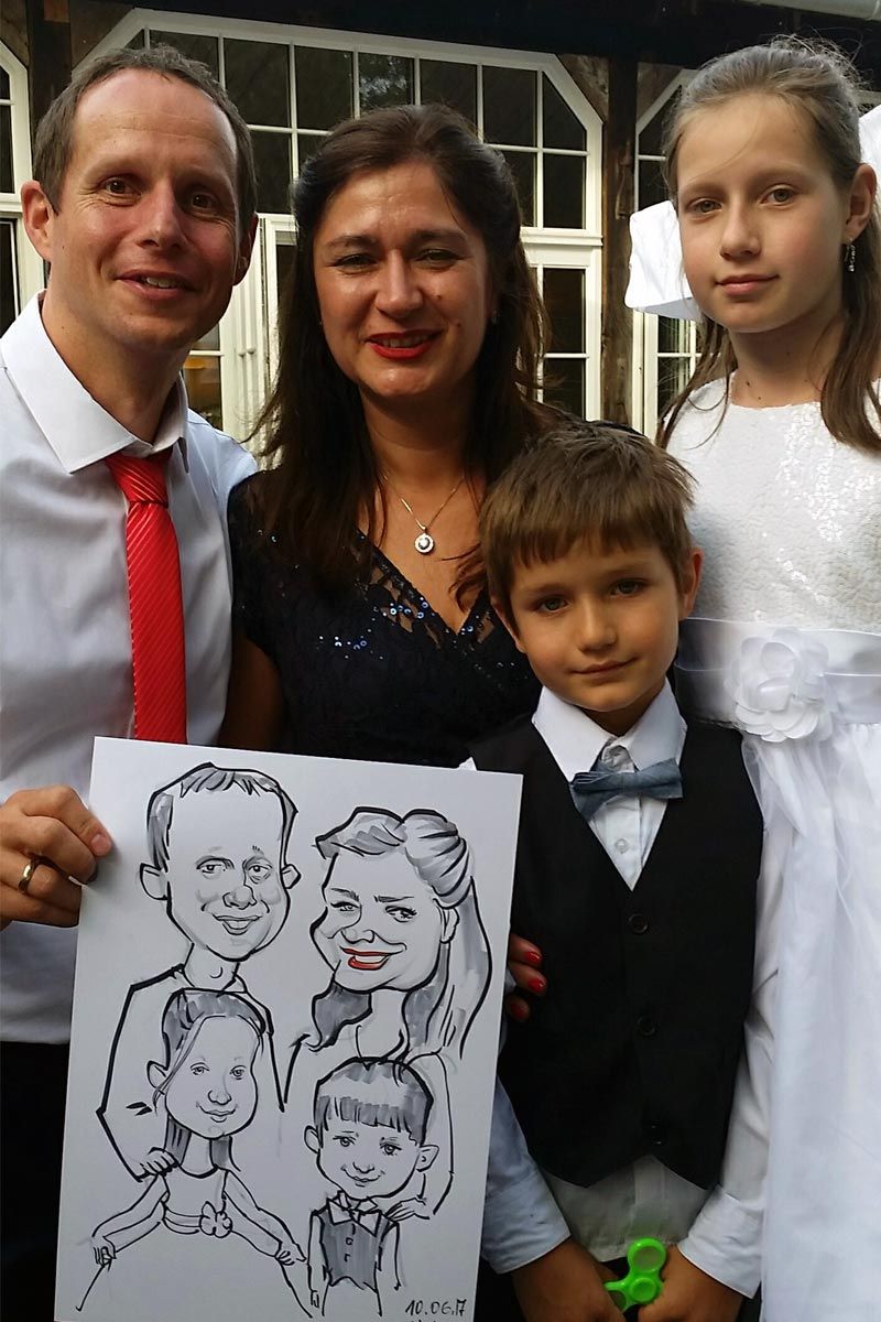 eine Familie steht nebeneinander und hält eine Karikatur ihrer Familie