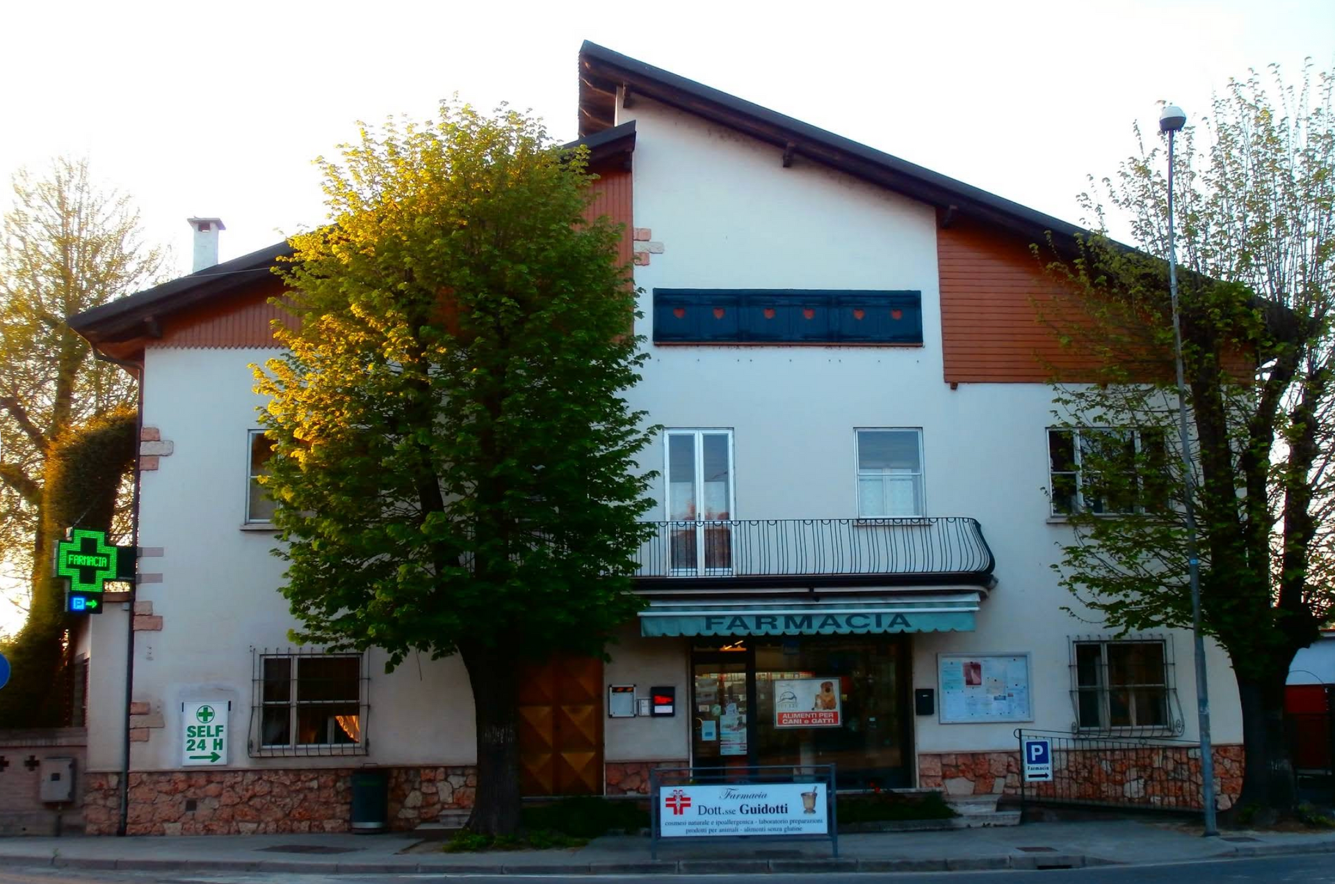 Un edificio a due piani con la farmacia guidotti al piano terra, con insegna e vetrina