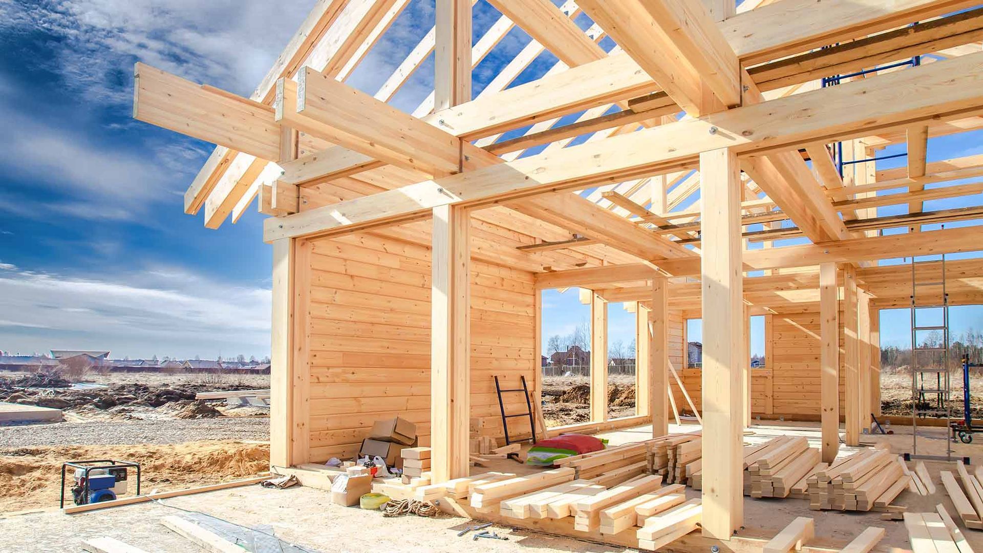 Ein im Bau befindliches Holzrahmenhaus mit sichtbaren Balken und Wüstenlandschaft im Hintergrund