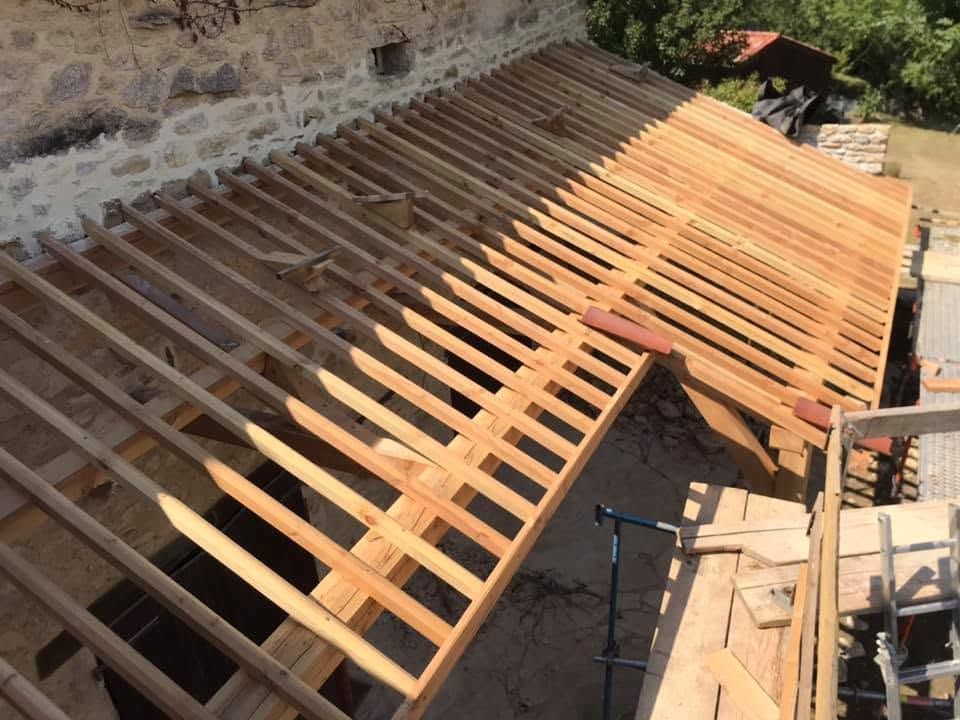 Charpente en bois de la maison avec fermes et poutres de toit en construction.