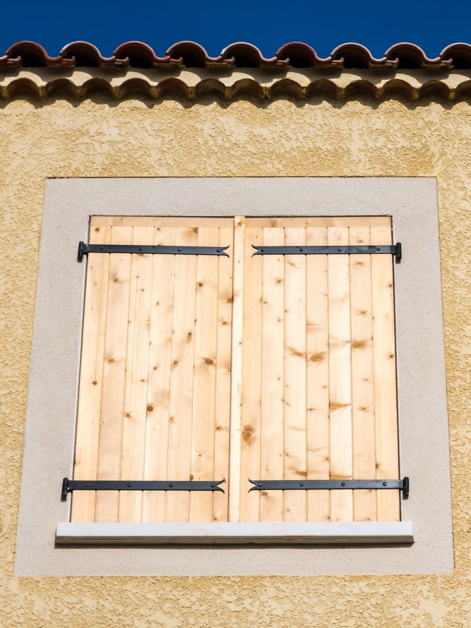 Fenêtre avec des volets en bois fermés.