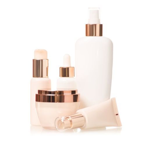 Un grupo de botellas y tubos de cosméticos sobre un fondo blanco.
