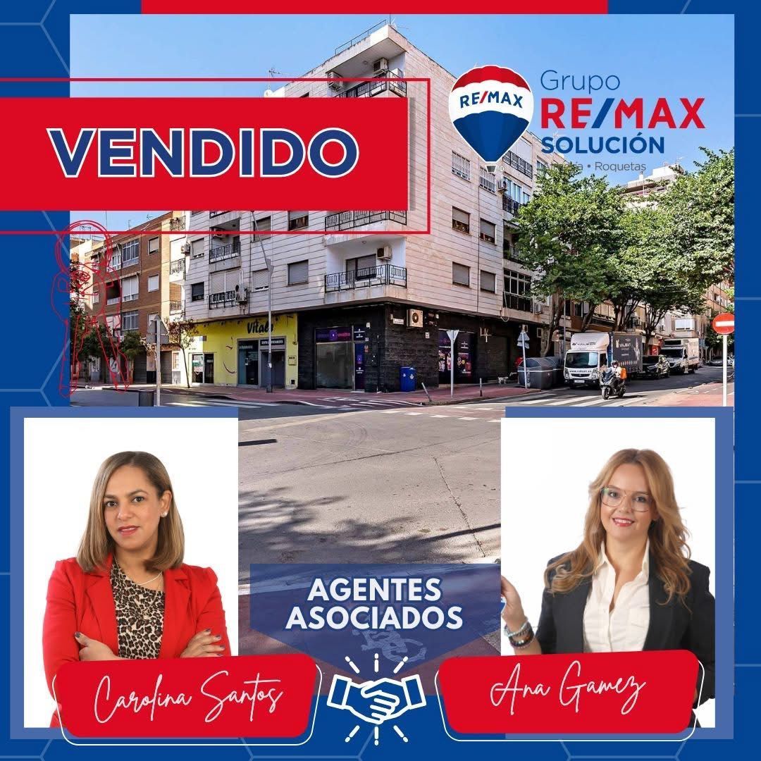 Dos mujeres están paradas una al lado de la otra frente a un edificio.