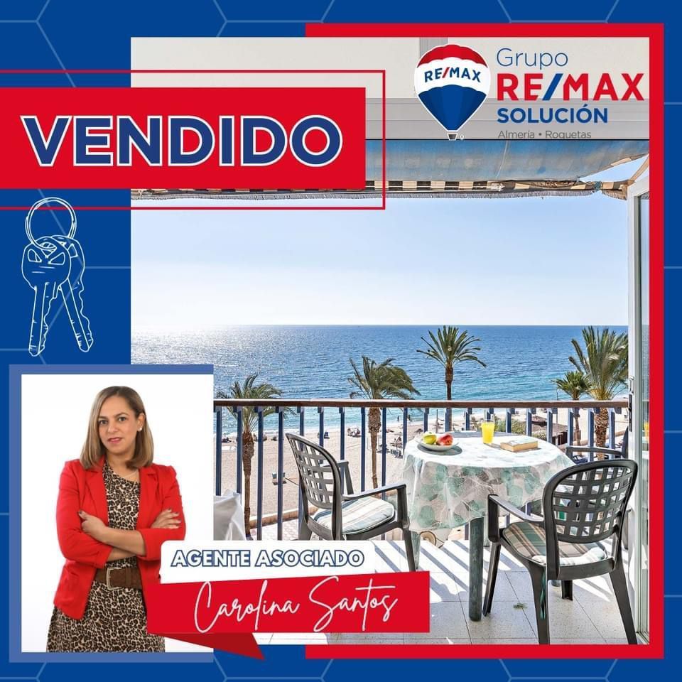 Una mujer está parada en un balcón con vista al océano.