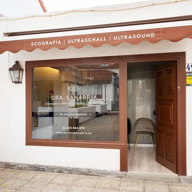 Un edificio blanco con un toldo marrón que dice ecografia ultraschall ultrasonido