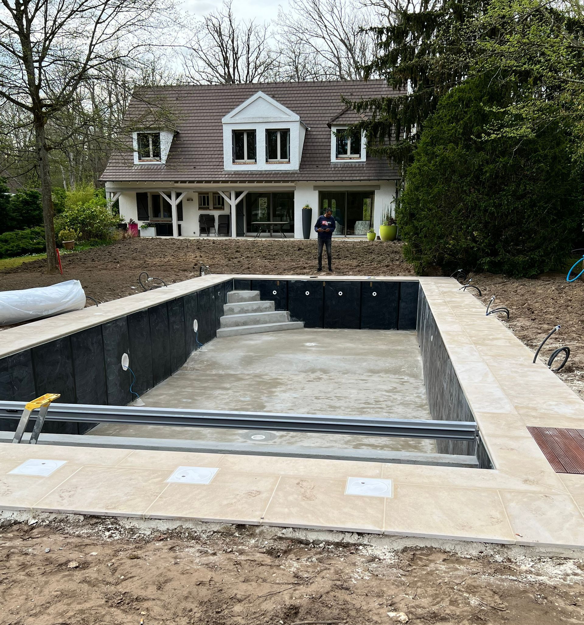 Piscine en construction devant une maison