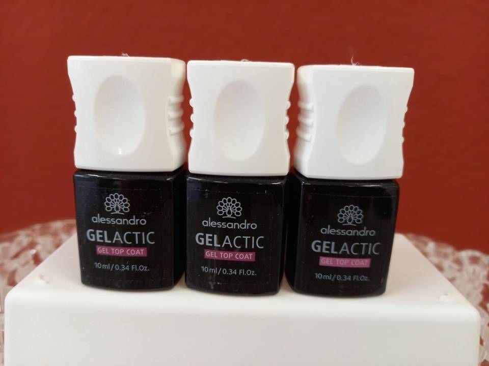 Drei Fläschchen „Alessandro Gelactic“ Nagellack-Überlack mit weißen Kappen und rotem Hintergrund.