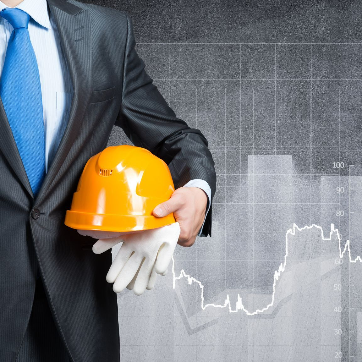 homme en costard avec un casque de chantier dans les mains