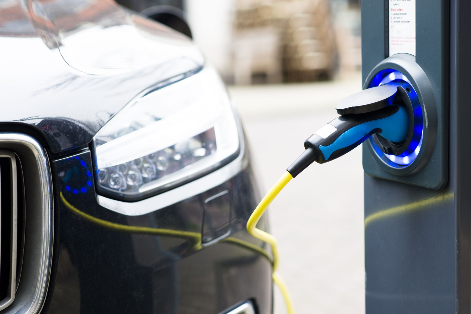 Voiture électrique en charge à une borne, avec un câble de charge branché.