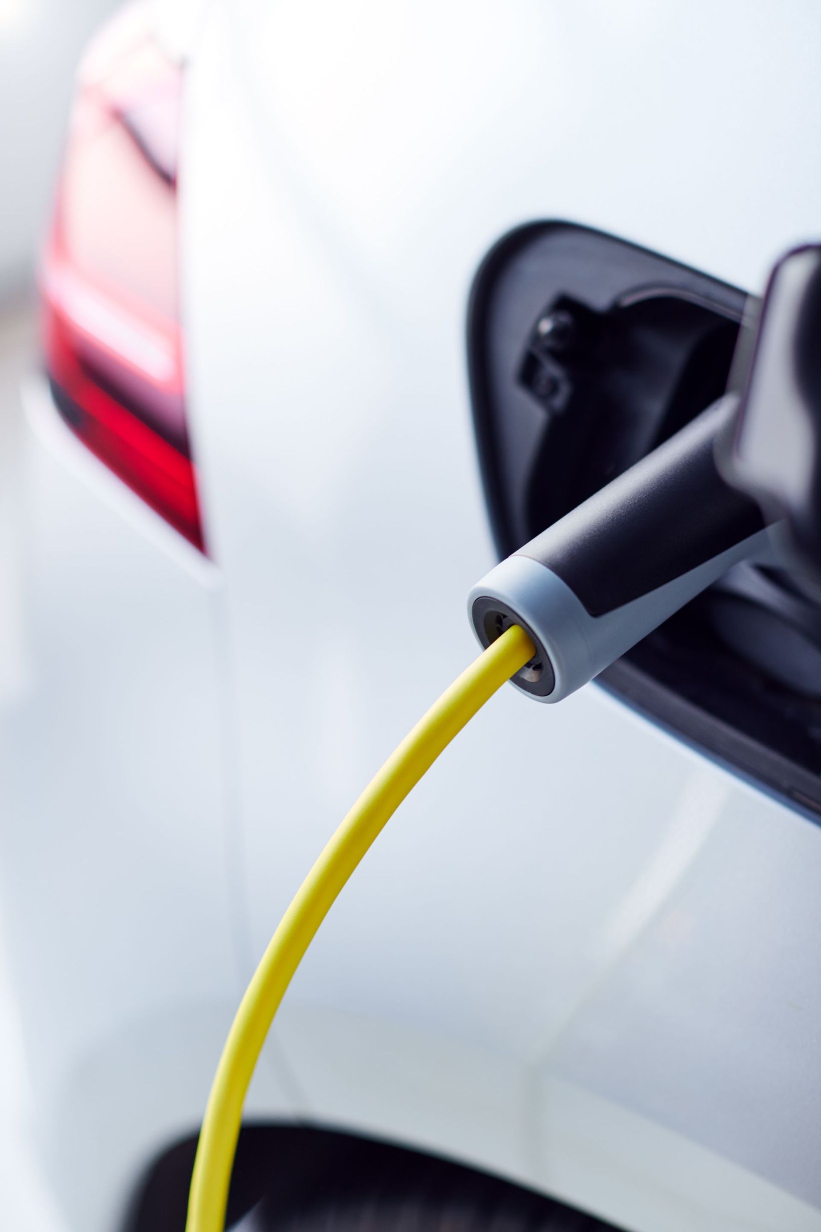 Voiture électrique en charge avec un câble branché sur la prise de charge du véhicule.