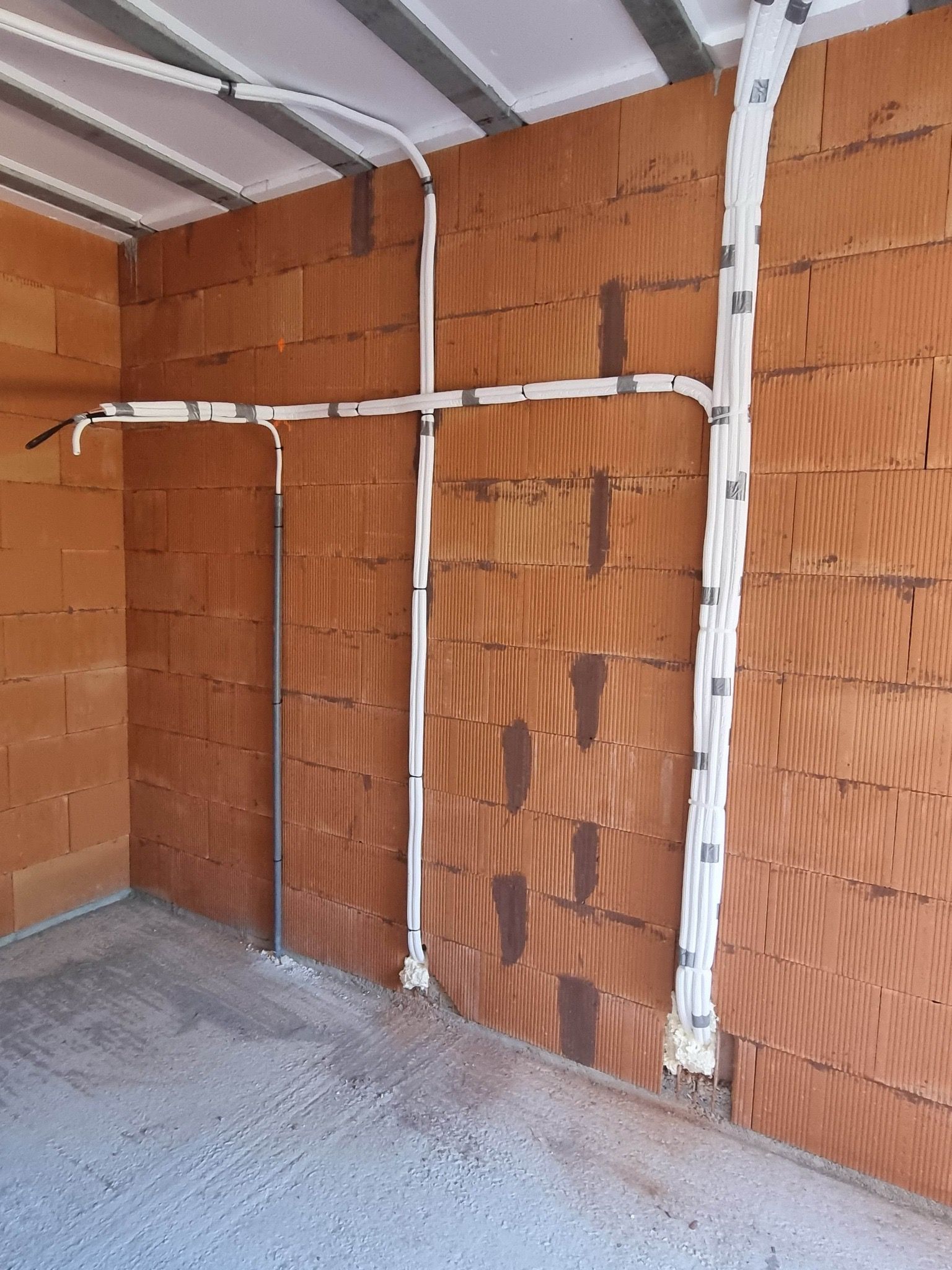 Pièce de stockage vide avec panneaux isolants, ossature et sol en béton.