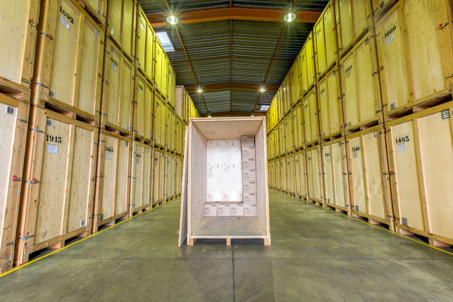 Un déménageur décharge des cartons d’un camion à l’entrée d’un bâtiment.